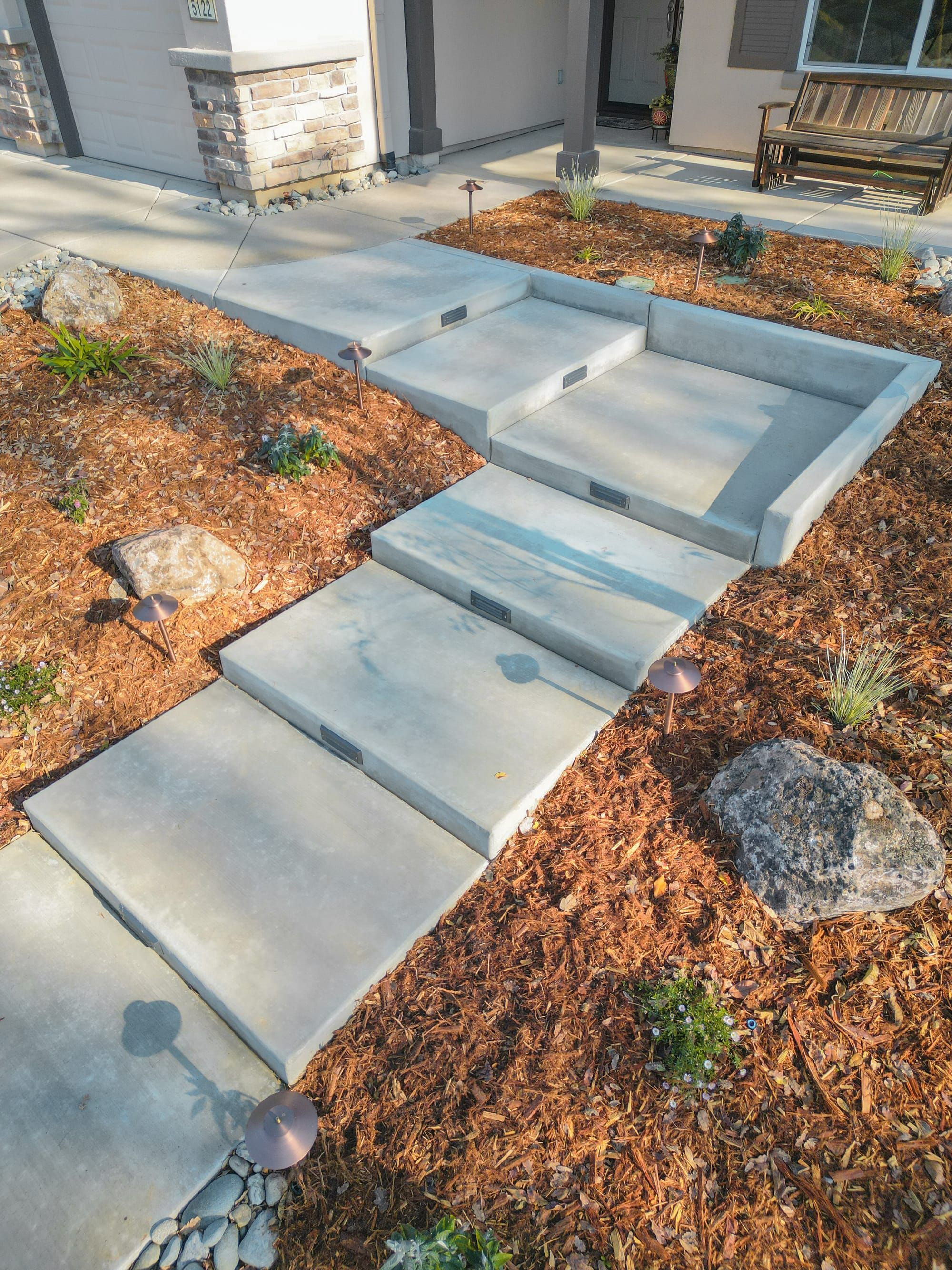 Custom concrete steps with integrated lighting and mulch landscaping in Sacramento