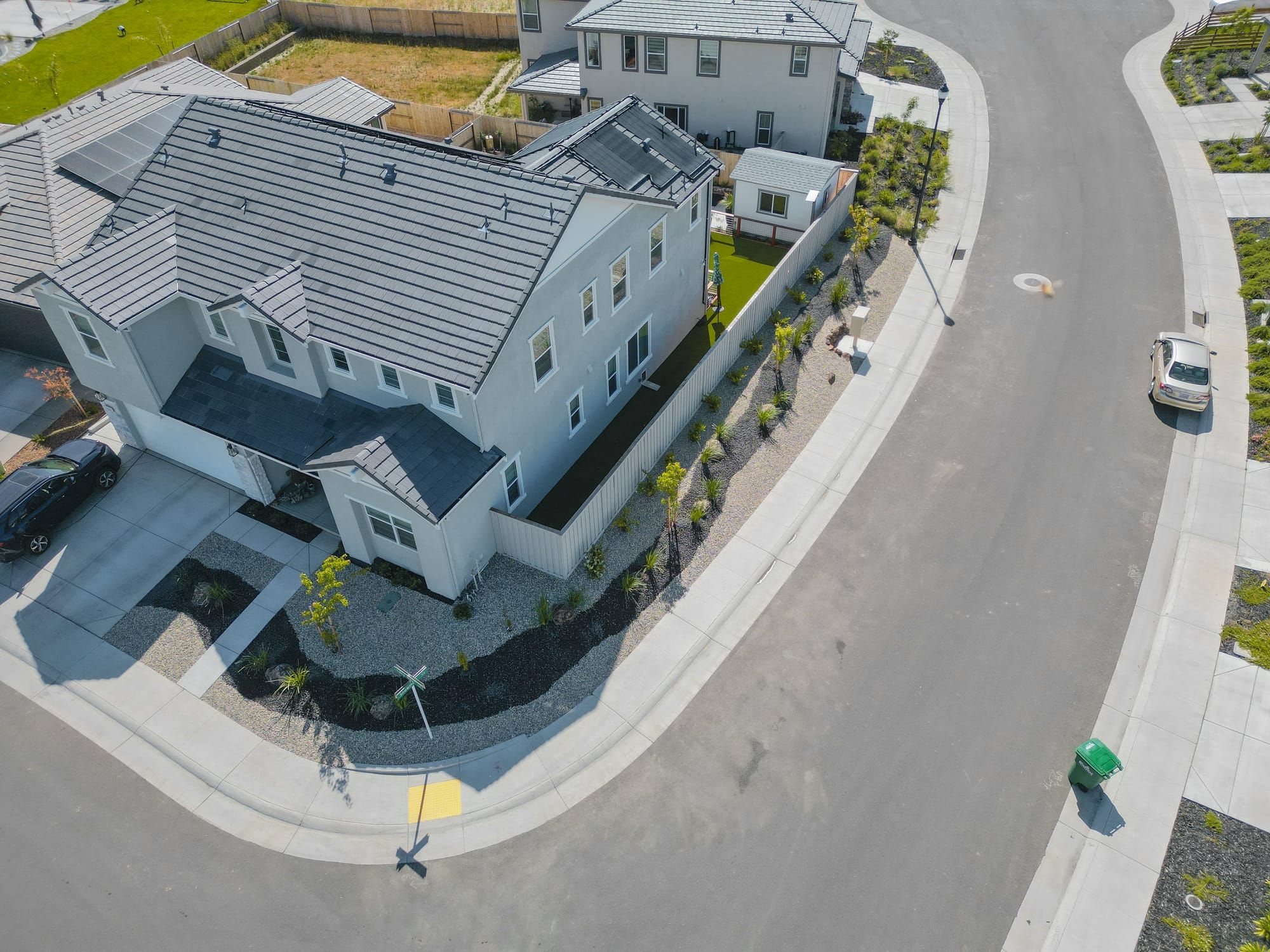 Aerial view of drought-tolerant front yard landscape installation with rock, plantings, and curb appeal in Sacramento