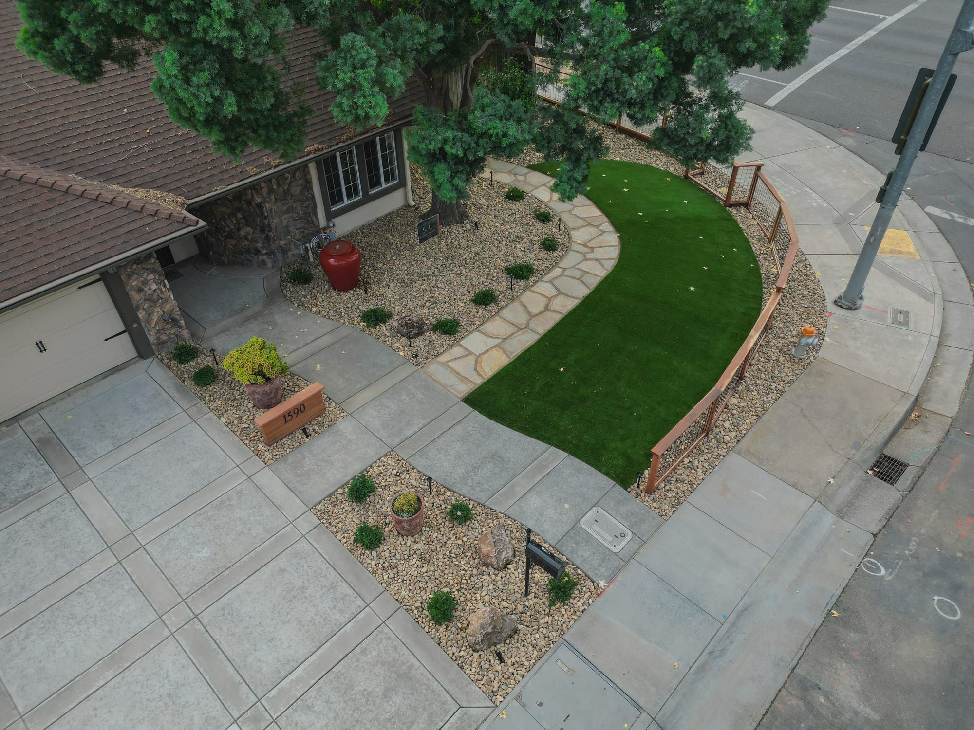 Front yard with rock landscaping, artificial turf, flagstone walkway, and boulder accents in Sacramento