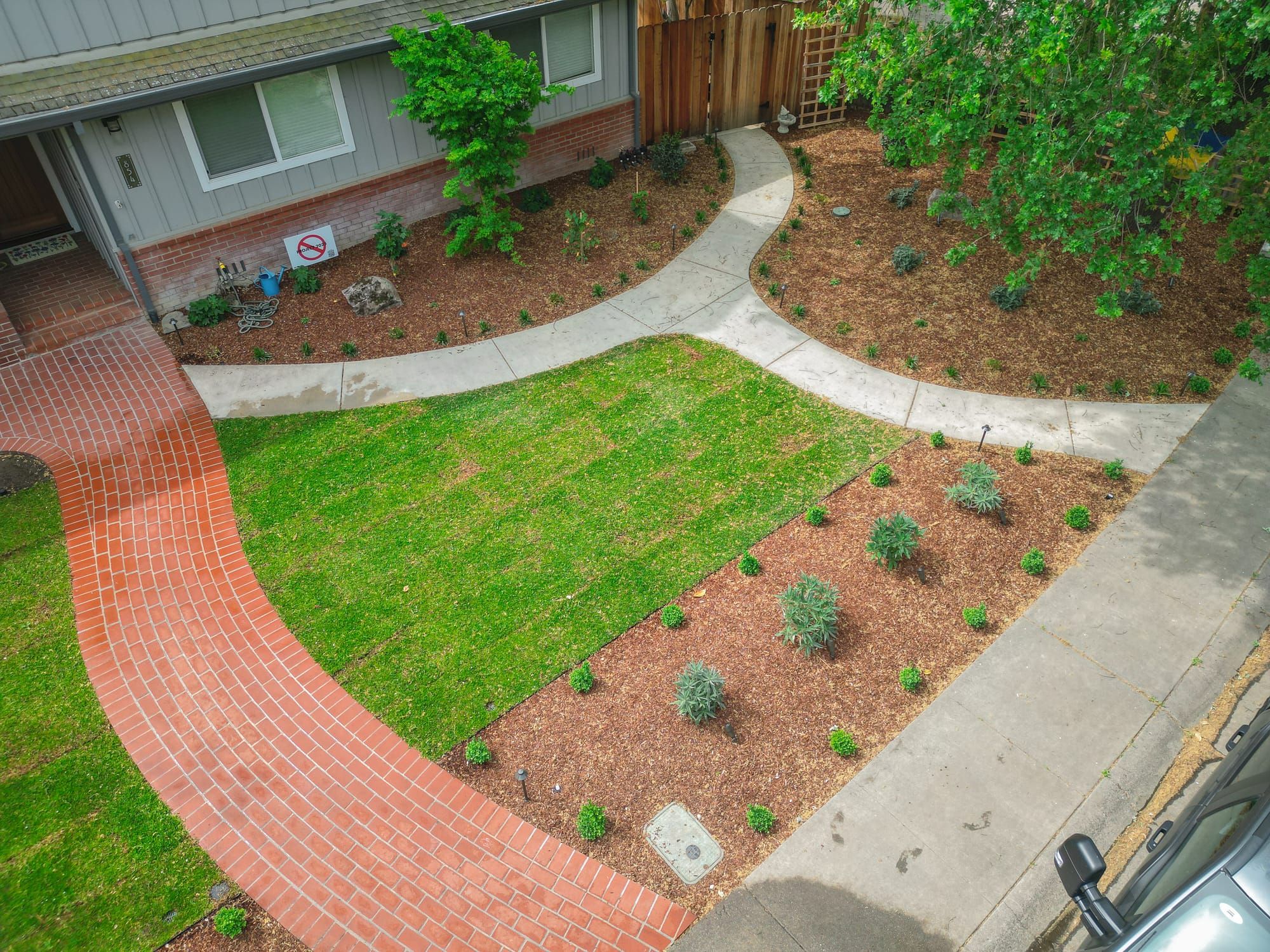 Front yard sod installation with brick walkway, mulch beds, and new plantings in Sacramento