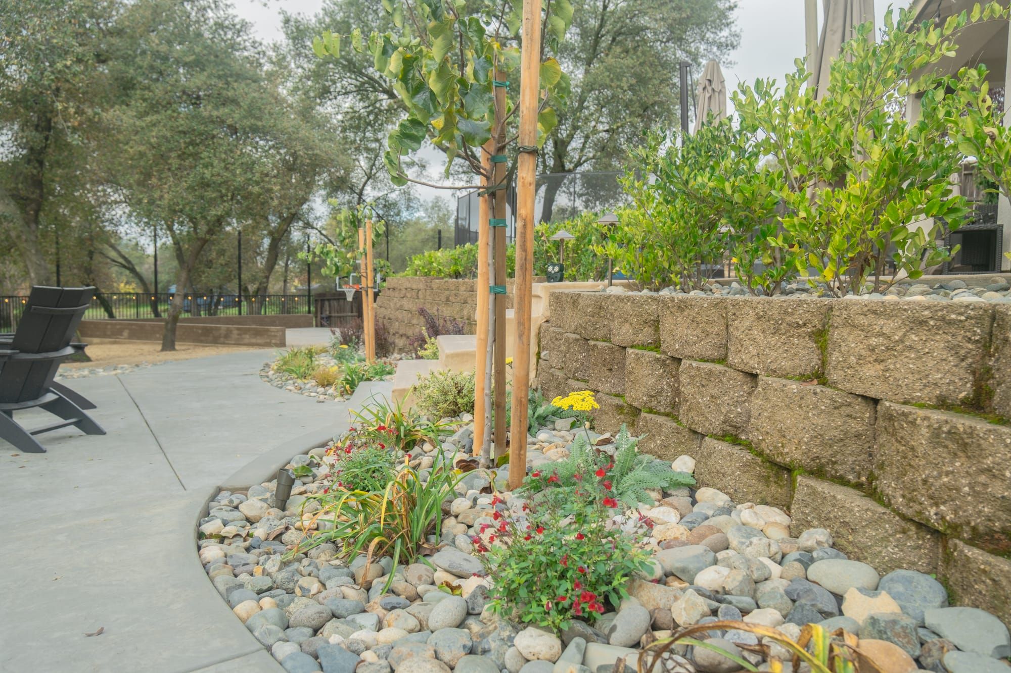 Retaining wall with colorful plantings and river rock in Sacramento